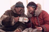 La gouverneure générale Adrienne Clarkson prend une tasse de thé iceberg en compagnie d’Abraham Pijamini, un aîné inuit (Grise Fiord, Nunavut). Date : 3 avril 2000. Photographe : Sgt Julien Dupuis, Rideau Hall. Référence : S/O.